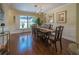 Bright dining room boasts elegant chandelier, wood floors, and natural light from a large window at 17544 Fairmeadow Dr, Tampa, FL 33647