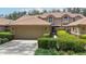 Charming home featuring a tile roof, a well-maintained lawn, and an attached two-car garage at 17544 Fairmeadow Dr, Tampa, FL 33647