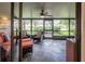 Screened lanai with comfortable seating, a ceiling fan, and views of the landscaped yard at 17544 Fairmeadow Dr, Tampa, FL 33647