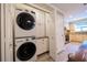 Convenient laundry room with stackable washer/dryer unit and extra storage space, plus access to kitchen at 17544 Fairmeadow Dr, Tampa, FL 33647