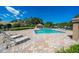 Community pool area with brick pavers, lounge chairs, and a covered gazebo with lush, mature landscaping at 17544 Fairmeadow Dr, Tampa, FL 33647