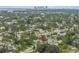 Aerial view of a house nestled among lush greenery, with a cityscape visible in the distance at 1878 New Hampshire Ne Ave, St Petersburg, FL 33703