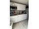 Efficient kitchen with white cabinets, stainless steel microwave, and tiled backsplash at 1900 W Kirby St, Tampa, FL 33604