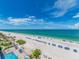Breathtaking view of the beach with crystal waters, white sand, and blue umbrellas at 20002 Gulf Blvd # 2803, Indian Shores, FL 33785