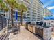 Outdoor grilling and dining area with lush tropical landscaping on the beach at 20002 Gulf Blvd # 2803, Indian Shores, FL 33785