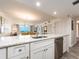 Bright kitchen with granite countertops and stainless steel dishwasher overlooks the living and dining areas at 20002 Gulf Blvd # 2803, Indian Shores, FL 33785