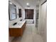 Modern bathroom featuring a soaking tub, a double vanity, and decorative wood-look panelling at 23220 Shining Star Dr, Land O Lakes, FL 34639