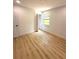 Well-lit bedroom with wood-look flooring, a window view, and a neutral color scheme at 23220 Shining Star Dr, Land O Lakes, FL 34639