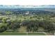 Aerial view of property featuring a tree filled yard, farmland, and residential area nearby at 3102 E Trapnell Rd, Plant City, FL 33566
