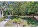 Shady backyard featuring mature trees, a concrete walkway, and partial fencing at 3102 E Trapnell Rd, Plant City, FL 33566