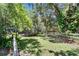 A fenced backyard with lush green grass and mature trees at 3102 E Trapnell Rd, Plant City, FL 33566