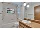 Well-lit bathroom featuring a bathtub, toilet, and a wooden vanity with a sink under globe lights at 3102 E Trapnell Rd, Plant City, FL 33566