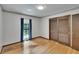 Bedroom featuring a window with curtains, hardwood floors, and a closet with sliding doors at 3102 E Trapnell Rd, Plant City, FL 33566