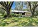 Beautiful single-story home nestled among mature trees and lush landscaping, features a metal roof at 3102 E Trapnell Rd, Plant City, FL 33566