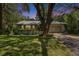 Charming single-story home boasts lush landscaping, mature trees, and a metal roof at 3102 E Trapnell Rd, Plant City, FL 33566