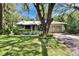 Charming single-story home with a metal roof, mature landscaping, and a two-car garage at 3102 E Trapnell Rd, Plant City, FL 33566