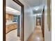 Hallway with wood flooring offering views into the kitchen with breakfast bar and a separate hallway with several doors at 3102 E Trapnell Rd, Plant City, FL 33566
