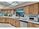 Galley kitchen featuring wood cabinets, white marble countertops, and stainless steel appliances at 3102 E Trapnell Rd, Plant City, FL 33566
