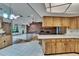 Cozy living room with a brick fireplace, adjacent to the kitchen with view of skylight and front facing windows at 3102 E Trapnell Rd, Plant City, FL 33566