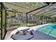 Well-maintained screened in-ground pool featuring a picnic table and peaceful outdoor views at 3102 E Trapnell Rd, Plant City, FL 33566