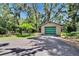 Tan shed with green door set on expansive green lot with mature trees at 3102 E Trapnell Rd, Plant City, FL 33566