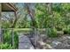 Fenced side yard showcasing mature trees, lush plantings, and a charming walkway at 3102 E Trapnell Rd, Plant City, FL 33566