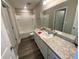 The bathroom features wood look flooring, a shower-tub combo, and a vanity with counter space at 35233 White Water Lily Way, Zephyrhills, FL 33541