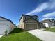 A two-story home featuring gray siding, a two-car garage, well-maintained lawn, and simple landscaping at 35233 White Water Lily Way, Zephyrhills, FL 33541