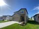 A two-story home featuring gray siding, a two-car garage, well-maintained lawn, and simple landscaping at 35233 White Water Lily Way, Zephyrhills, FL 33541