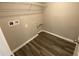 Laundry room includes wood-look floors, wire shelf, and hookups for washer and dryer at 35233 White Water Lily Way, Zephyrhills, FL 33541