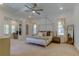 Spacious bedroom with a four-poster bed, neutral tones, and access to a sitting area at 4372 Night Star Trl, Odessa, FL 33556