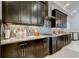 Modern kitchen featuring sleek black cabinets, stainless steel range hood, and beautiful backsplash at 4372 Night Star Trl, Odessa, FL 33556