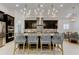 Contemporary kitchen showcases a large island with seating, stylish dark cabinetry, and elegant lighting fixtures at 4372 Night Star Trl, Odessa, FL 33556