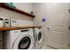 Laundry area equipped with a front-load washer and dryer, a long countertop, and a control panel at 4372 Night Star Trl, Odessa, FL 33556