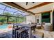 Covered outdoor area with a dining table and seating with views of the pool and backyard at 4372 Night Star Trl, Odessa, FL 33556