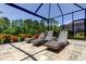 Outdoor patio featuring three lounge chairs with a manicured garden and wrought iron fence at 4372 Night Star Trl, Odessa, FL 33556