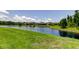 Scenic view of a large pond surrounded by green grass and beautiful homes in a lovely neighborhood at 4372 Night Star Trl, Odessa, FL 33556