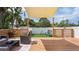 Inviting backyard deck with outdoor seating, artificial turf, and a shade cover at 500 62Nd S St, St Petersburg, FL 33707