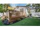 Landscaped backyard showcasing a deck with outdoor furniture, plants, and a white picket fence at 500 62Nd S St, St Petersburg, FL 33707