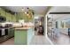 Charming kitchen with green cabinets, wooden countertops, and a view into the dining and living areas at 500 62Nd S St, St Petersburg, FL 33707