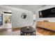 Bright living room with wood floors, a textured rug, round mirror, and modern TV console at 500 62Nd S St, St Petersburg, FL 33707