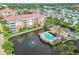 Aerial view showcasing a pool and clubhouse, nestled by a pond with fountain, surrounded by lush landscaping at 7903 Seminole Blvd # 2203, Seminole, FL 33772