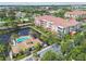 Aerial view showcasing a pool and clubhouse, nestled by a pond with fountain, surrounded by lush landscaping at 7903 Seminole Blvd # 2203, Seminole, FL 33772