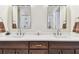 Bathroom featuring double sinks with marble countertops and dark wood cabinetry beneath matching mirrors at 7903 Seminole Blvd # 2203, Seminole, FL 33772