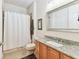 Bathroom featuring oak vanity with granite countertop and shower tub combination with white curtain at 7903 Seminole Blvd # 2203, Seminole, FL 33772