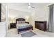 Clean bedroom featuring neutral carpeting, contemporary ceiling fan, and dark wooden furniture at 7903 Seminole Blvd # 2203, Seminole, FL 33772