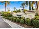 Elegant community entrance sign with lush landscaping and mature palm trees, creating a welcoming atmosphere at 7903 Seminole Blvd # 2203, Seminole, FL 33772