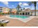Sparkling community pool surrounded by lounge chairs, mature palm trees, and manicured landscaping for a resort-like experience at 7903 Seminole Blvd # 2203, Seminole, FL 33772