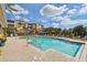 Resort-style swimming pool with ample lounge chairs, attractive palm trees, and a tranquil water feature beyond the fence at 7903 Seminole Blvd # 2203, Seminole, FL 33772