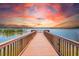 Scenic view of a wooden dock extending into a tranquil lake under a vibrant, colorful sky at 7903 Seminole Blvd # 2203, Seminole, FL 33772